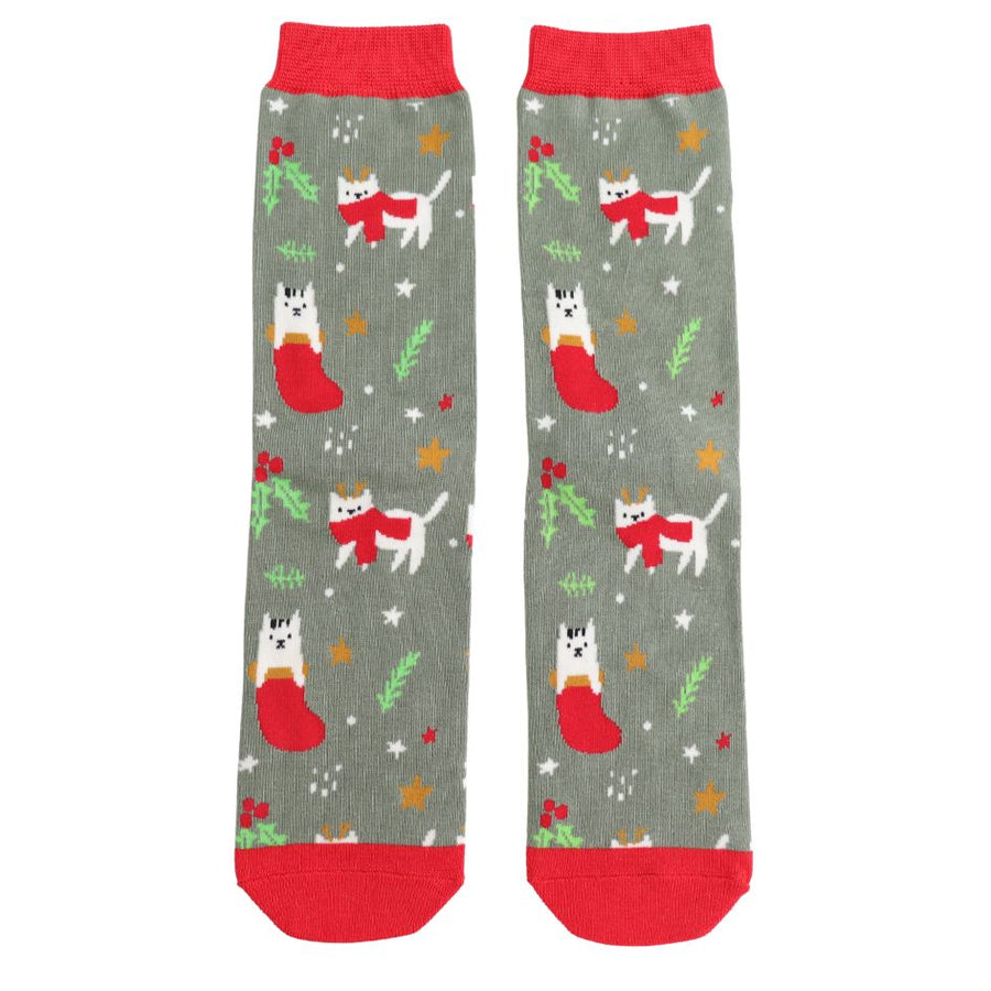 A pair of green grey socks decorated with white cats wearing red scarves. On a background of stars and mistletoe. 