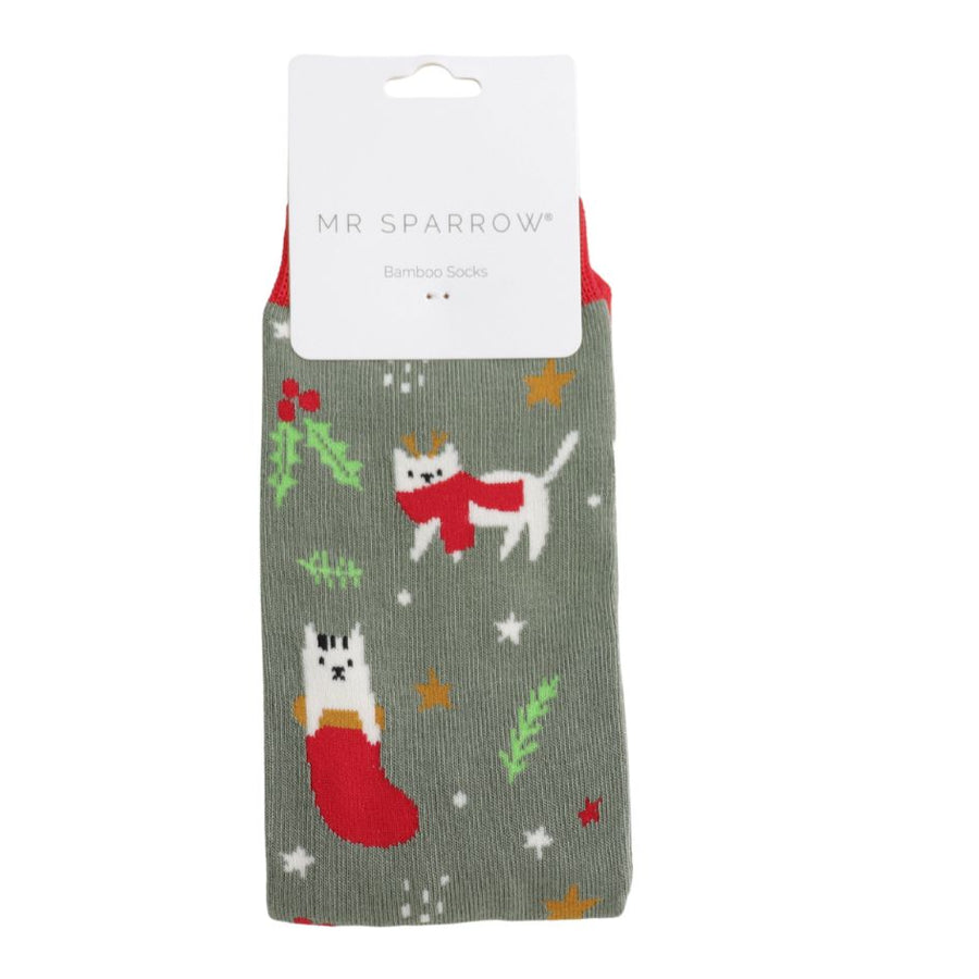 A Green khaki sock adorned with white cats and red stockings. Set against a christmas background. 