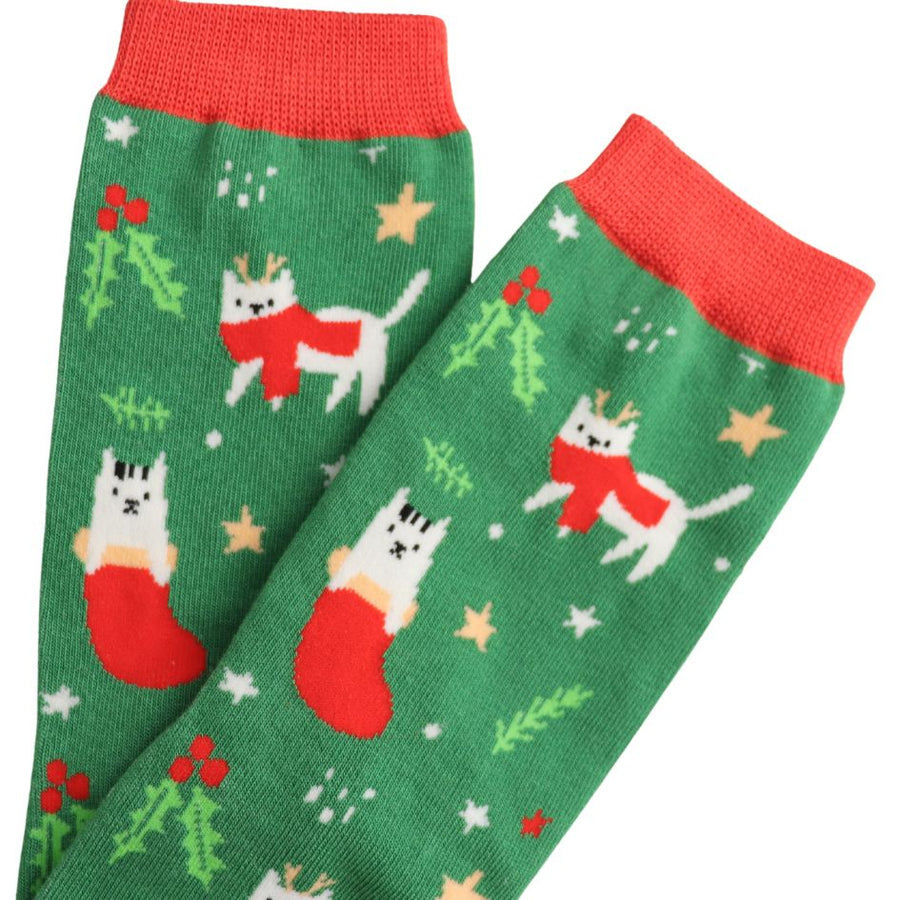 White festive cats on a green sock with background stars and foliage