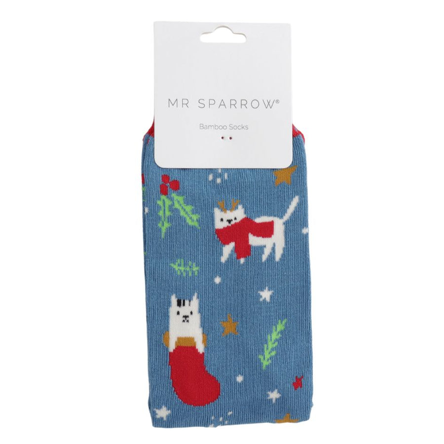 A denim blue sock decorated with a white cat wearing a scarf and cat in a stocking. 