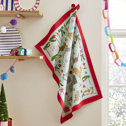 Decorative Christmas-themed  tea towel featuring cats and baubles with red border hanging on a wall.