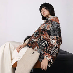 Person wearing a patterned coat sitting on a chair against a white background