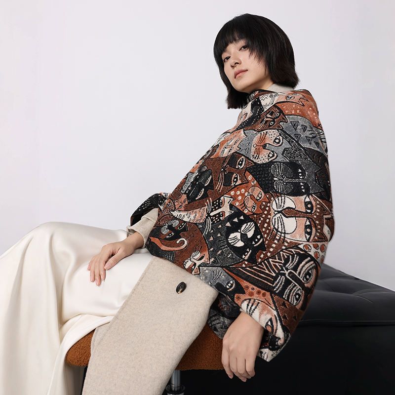 Person wearing a patterned coat sitting on a chair against a white background