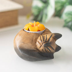 Curled Cat Wooden Tealight Holder in natural setting with lit flower-shaped tealight, handcarved Monkey Pod Wood