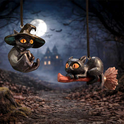 Two black cat figurines on a broom against a Halloween-themed background with a full moon.