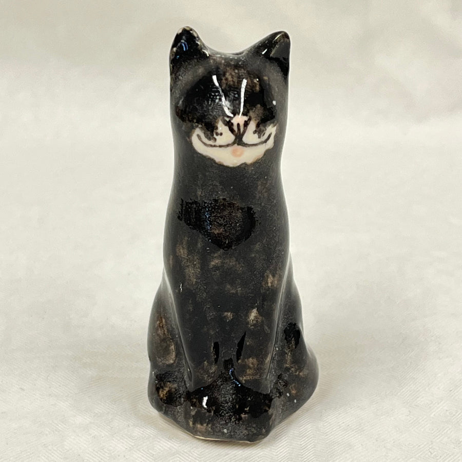 Ceramic cat figurine on a light gray background. winstanley black and white lucky cat