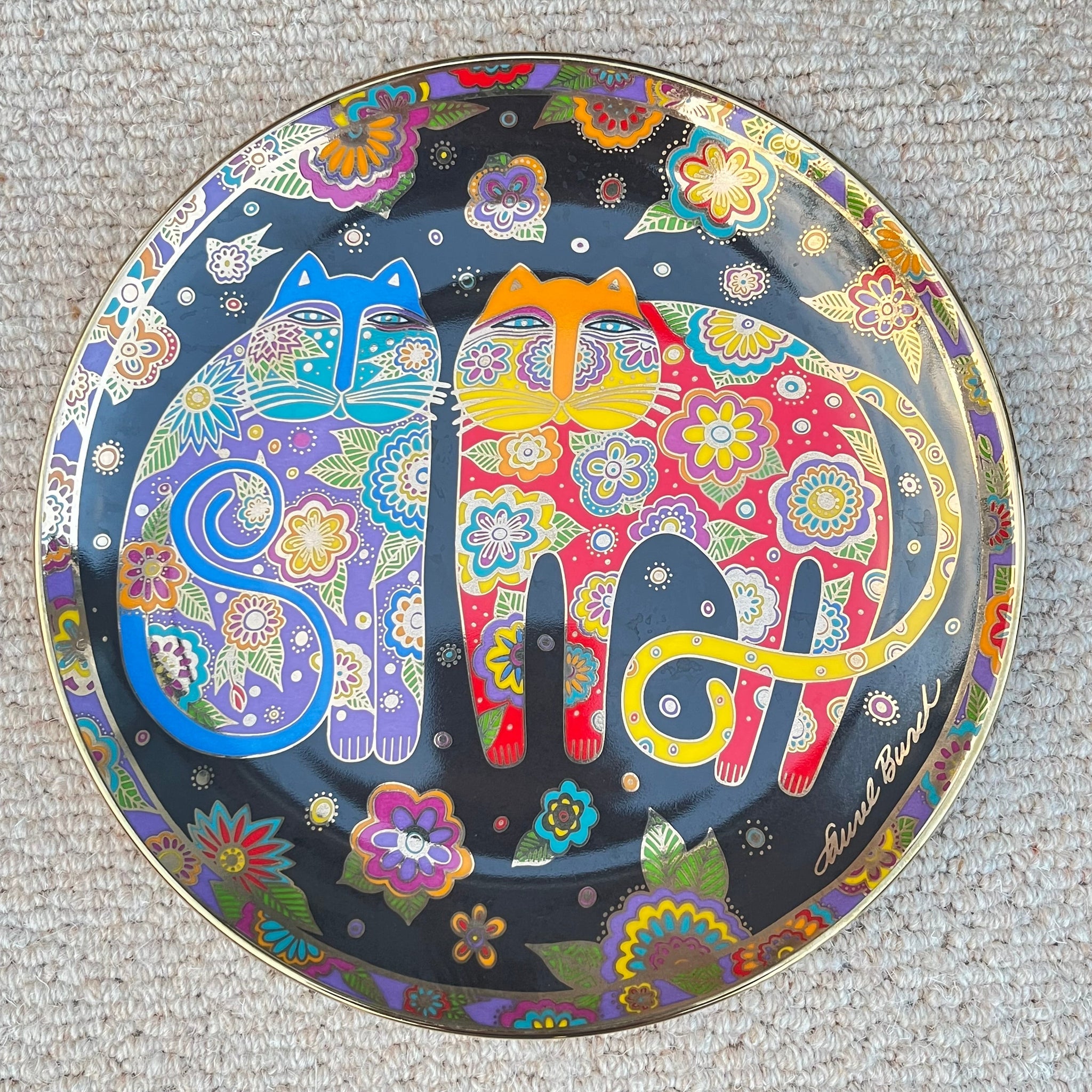 Decorative plate with colorful cat design on a textured surface