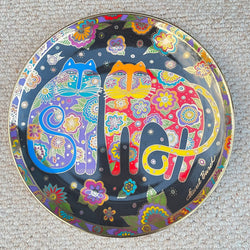 Decorative plate with colorful cat design on a textured surface