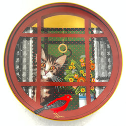 Decorative plate with a window design featuring a cat and bird, surrounded by floral patterns.