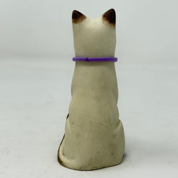 A  Lucky Cat figure hand painted to look like a chocolate point Siamese with a purple collar and heart pendant. Rear view.
