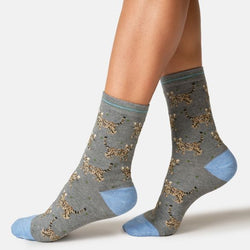 A pair of grey crew socks with a bengal cat pattern and light blue heels, toes, and cuffs, shown on a model's feet