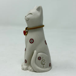 A white resin lucky cat figurine with a brown collar, red heart charm and Yorkshire Rose decoration - side view with LCY logo visible