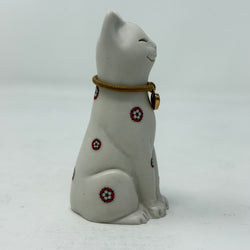 A white resin lucky cat figurine with a brown collar, red heart charm and Yorkshire Rose decoration - side view
