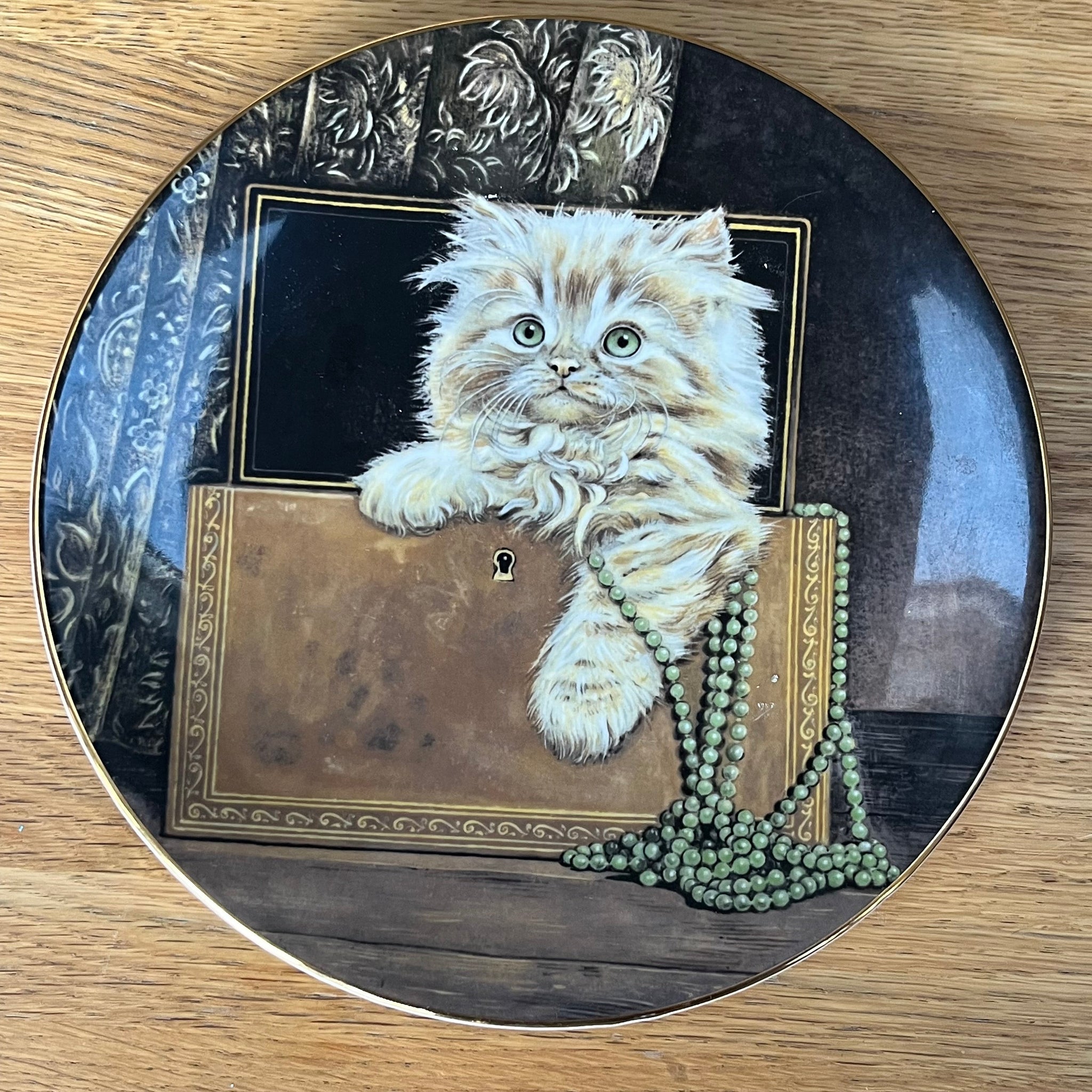 Decorative plate with a cat illustration on a wooden surface