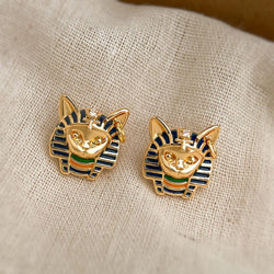 A pair of gold-toned Egyptian pharaoh cat stud earrings with blue and green enamel details