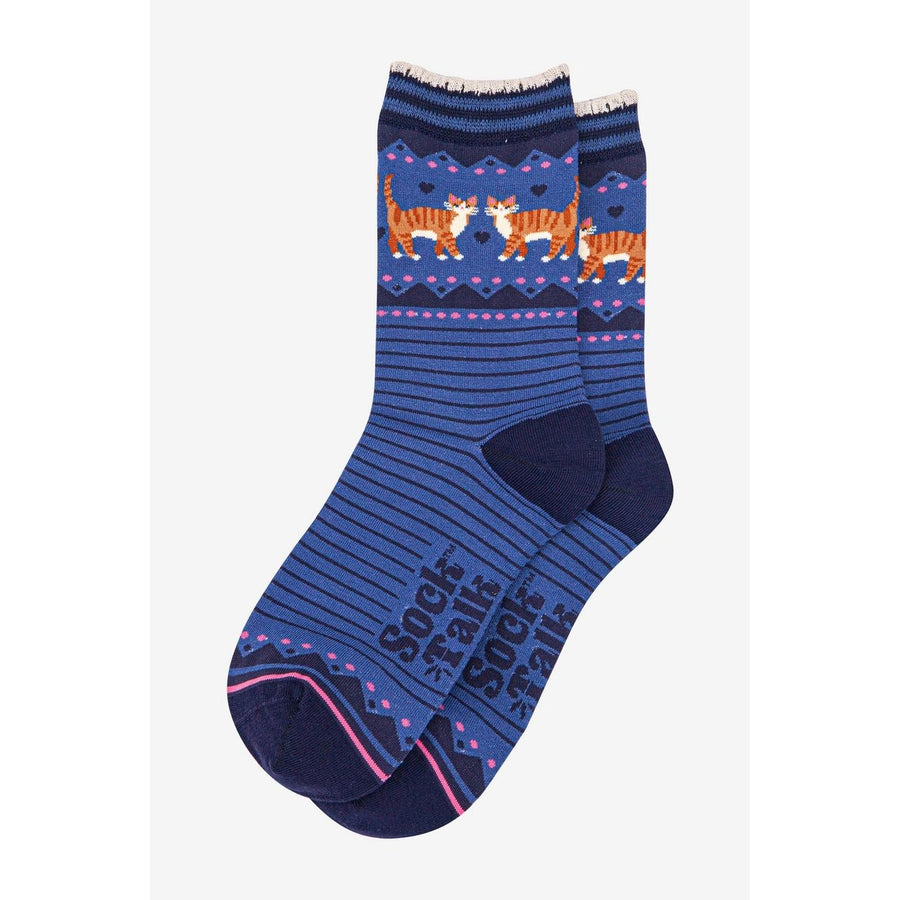 A pair of blue crew socks with a pattern of orange tabby cats on a navy background, featuring pink and white accents