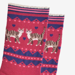A pair of crew socks with a pink and navy blue Fair Isle pattern featuring two tabby cats and hearts, shown on a plain white background.