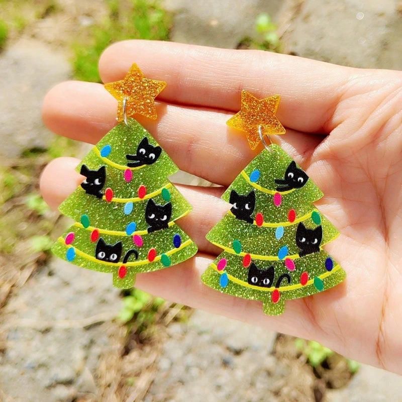 Green glittery Christmas tree earrings with black cats and colourful lights held in a hand