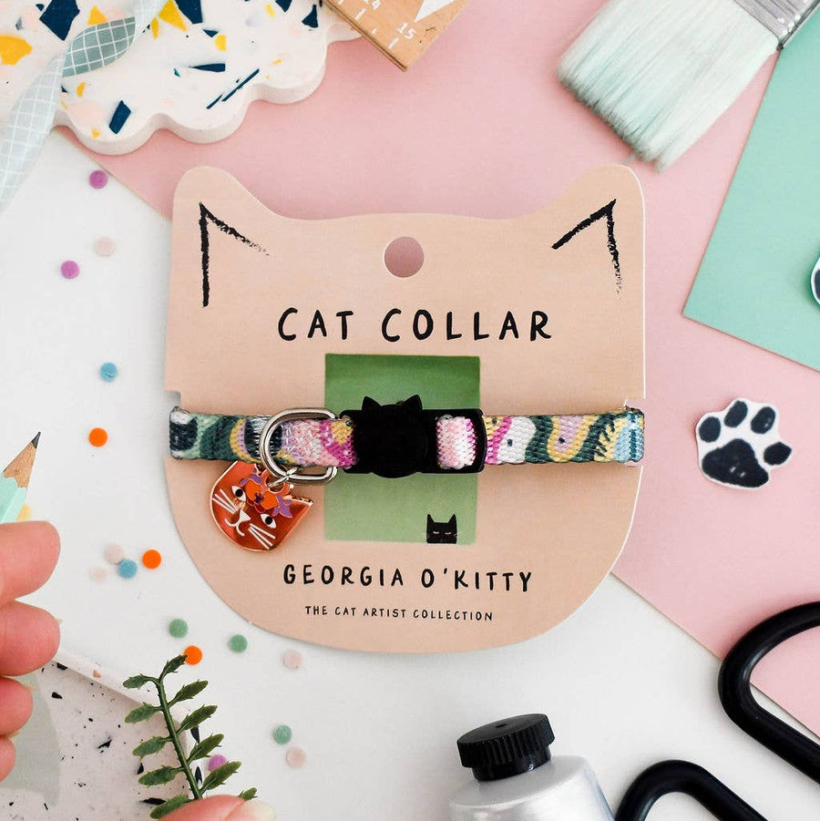A colourful patterned cat collar with a small cat-shaped charm is displayed on a beige cardboard card labelled 'GEORGIA O'KITTY'