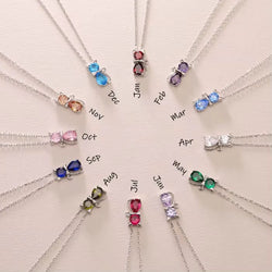 A collection of cat-shaped birthstone pendants, each pendant is a different colour representing birth months