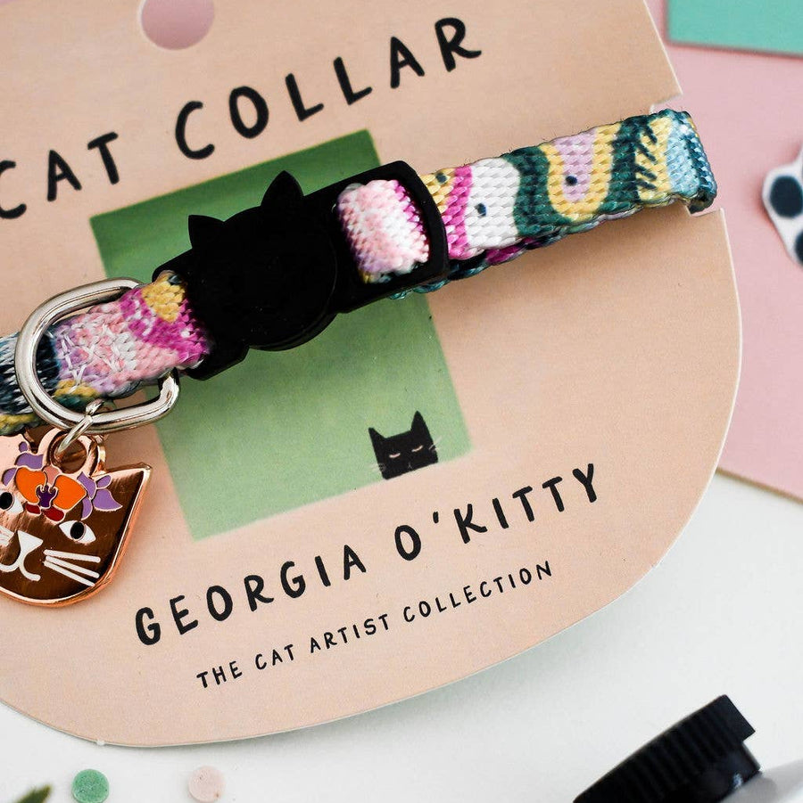 A colourful woven cat collar with a black cat-shaped buckle and a small metal cat hanging tag