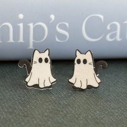 A pair of ghost-shaped cat stud earrings with black outlines and eyes