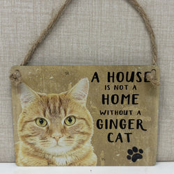 A rustic hanging sign with a ginger cat illustration and the text 'A HOUSE IS NOT A HOME WITHOUT A GINGER CAT' plus a black paw print