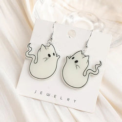 A pair of acrylic earrings designed as white ghost cats with outstretched tails, displayed on a card