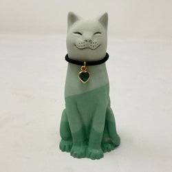 A resin lucky cat figurine in a sitting position, featuring a two-tone green and white color scheme