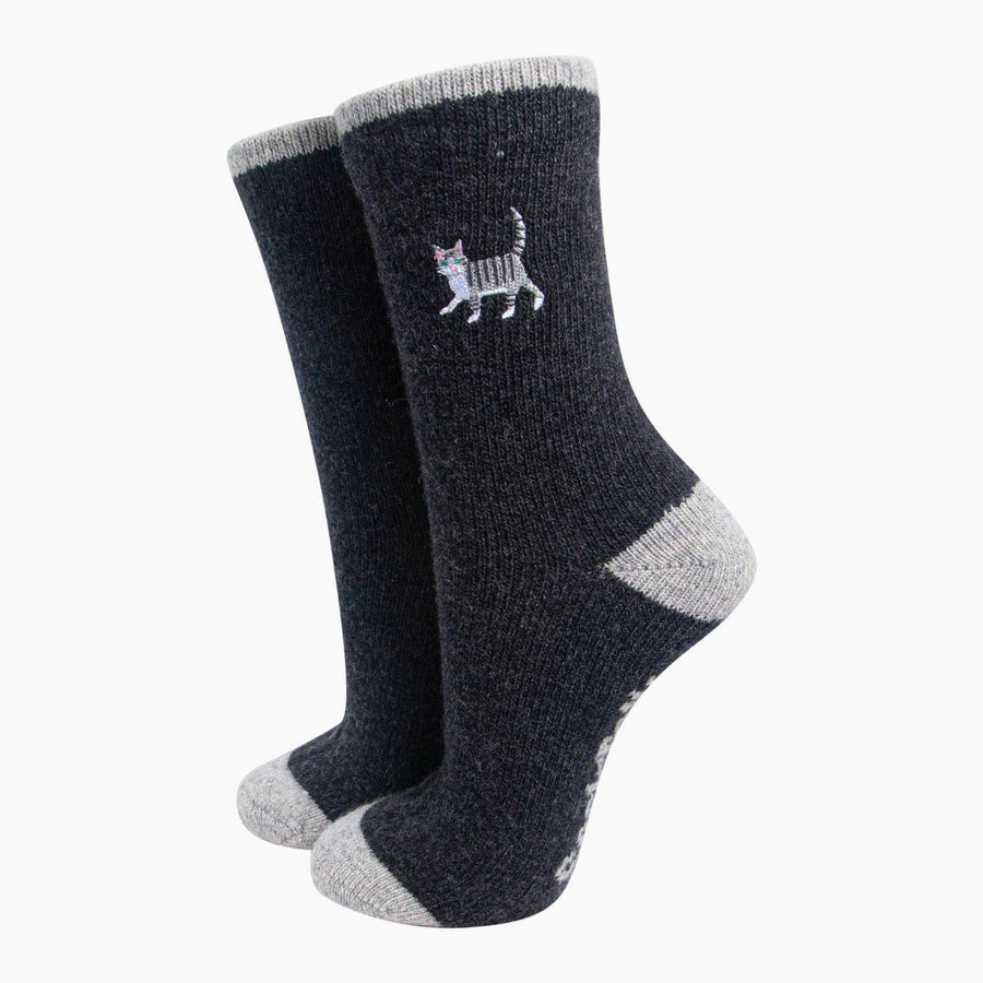 A pair of charcoal crew socks with light gray heels, toes, and cuffs, featuring a small embroidered cat logo on the side