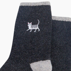 A pair of dark charcoal grey heathered crew socks with light gray ribbed cuffs, heels, and toes, featuring a small embroidered cat