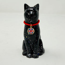 A glossy black lucky cat figurine with silver holographic speckles, wearing a bright red collar with a round pendant featuring the Union Jack flag