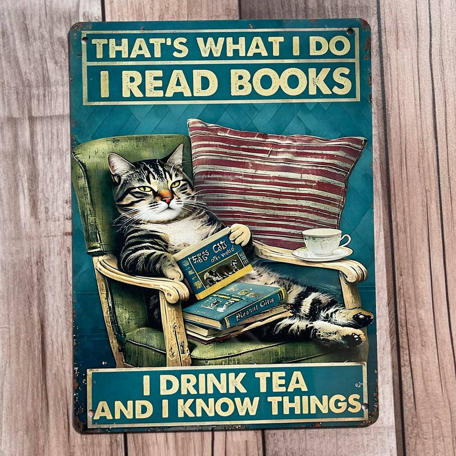 Decorative sign with a cat reading a book, drinking tea, and text on a wooden surface
