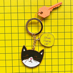 Keychain with cat design and 'I Speak Fluent Cat' tag on a yellow grid background
