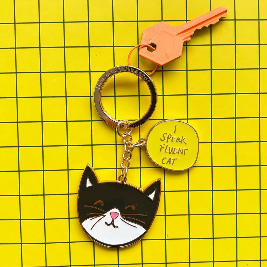 Keychain with cat design and 'I Speak Fluent Cat' tag on a yellow grid background
