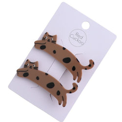 Two brown cat-shaped hair clips with black spots, attached to a white display card labeled 'Red Cuckoo' on a white background.