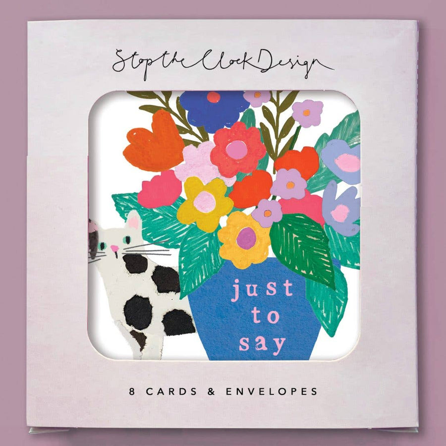 A boxed card set, shown in a white square package with a cat, colourful floral illustration and the words 'just to say' 