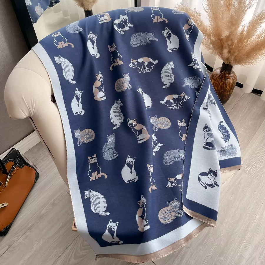Navy blue scarf with cat pattern draped over a chair in a room.