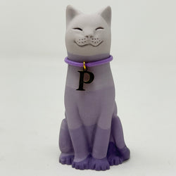 A lavender lucky cat figurine,with a lavender collar and a gold letter P charm