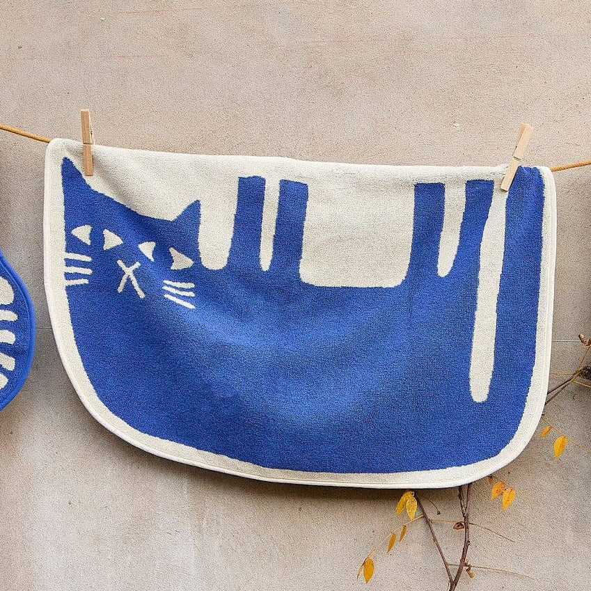 Blue cat on its side on a white background hanging on a line