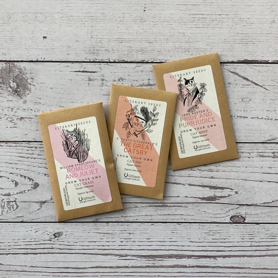 Three small kraft paper seed packets with illustrated labels including 'Romeow and Juliet' and 'The Great Catsby'