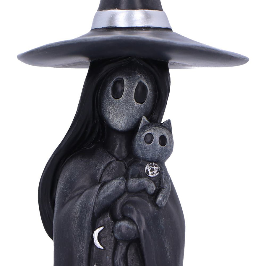 Statue of a witch holding a small cat with a white background