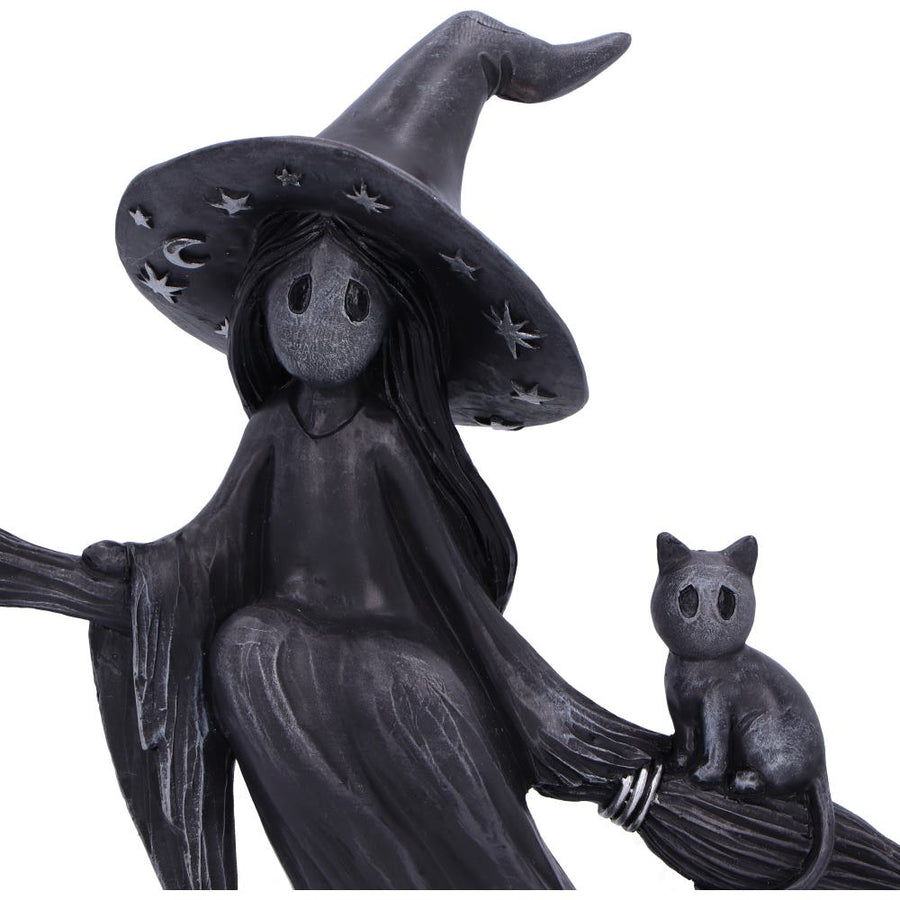 Statue of a witch with a black hat and a black cat on a broomstick against a white background
