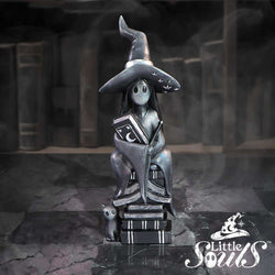 Statue of a witch with a hat and a cat on a dark background with 'Little Souls' branding.