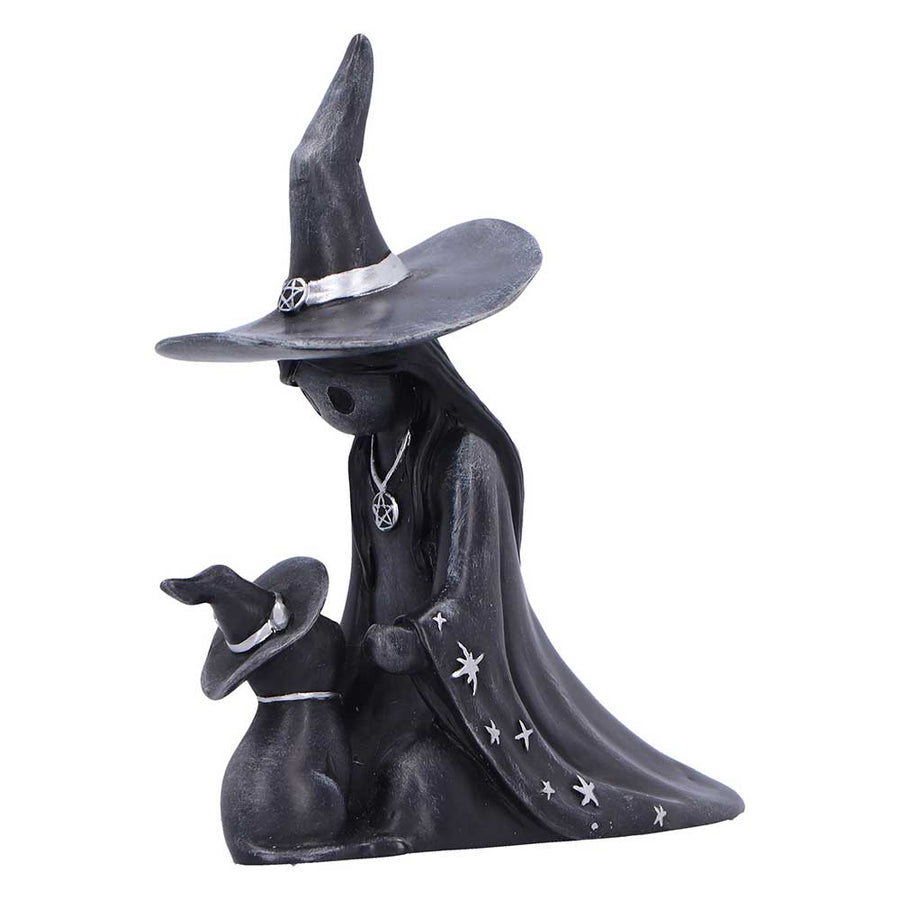 Statue of a witch with a black hat and cloak on a white background