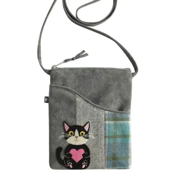 A grey fabric crossbody bag with an embroidered black-and-white cat holding a pink heart.