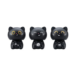 Three black cat-shaped figurines with yellow eyes and white facial details, each holding a small object, shown on a plain white background.