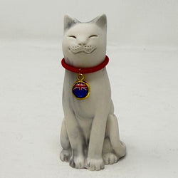 A white and grey resin Lucky Cat figurine wearing a red collar with a blue and red flag charm featuring a Union Jack design, set against a plain light gray background.
