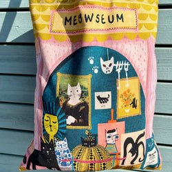 A colourful canvas tote bag with yellow handles, featuring a whimsical cat-themed illustration and the text 'MEOWSEUM'
