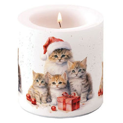 Lit candle with a design of cute tabby kittens wearing Santa hats scattered baubles and a bow wrapped present on a white background